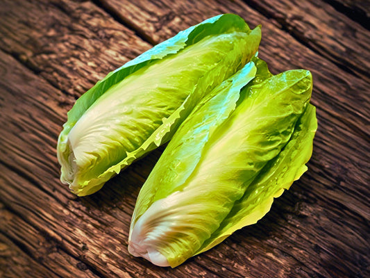Two heads of fresh green lettuce on a wooden surface.
