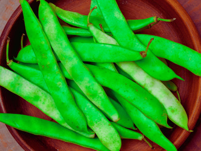 A wooden bowl filled with fresh green beans.